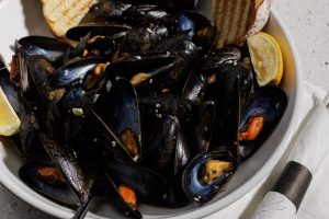 Bucket of steamed mussels with lemon and grilled bread at PJ Lobster House happy hour in Port Jefferson, NY
